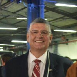 Foto do cliente Jorge Almeida, de terno escuro e gravata vermelha