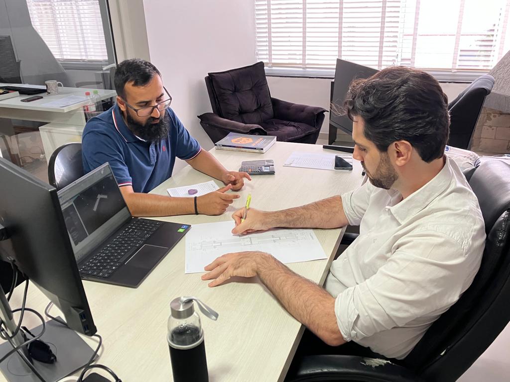 Profissionais da M3 Engenharia analisando projeto técnico na mesa do escritório